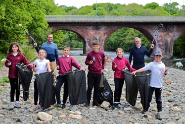 SUMMER CLEAN-UP . . . collecting litter on the banks of the River Esk this week were pupils from Canonbie Primary School and local MSP Oliver Mundell, back, left, and MP David Mundell The pupils, front, left to right, are: Danielle Ward, Maisie Hay, Daniel Stevens, Jayden McVittie, Grace Ellwood and Campbell Graham